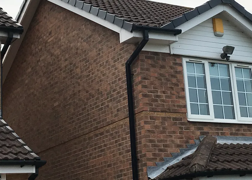 a brown brick house with a white window